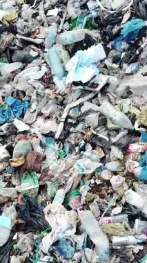 Çevre kirliliği sorunlarını vurgulayan büyük bir çöp sahasında plastik ve atık yığını.