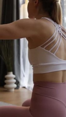 Yoga antrenmanı sırasında ince bir kadının meditasyon yaptığı yakın çekim. Dikey video.