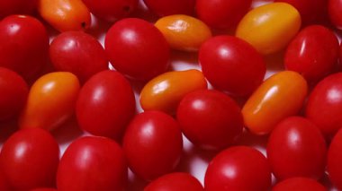 Değişik şekil ve boyutlarda kırmızı ve sarı kiraz domatesleri içeren canlı ve renkli bir ekran..