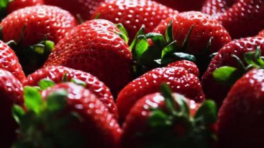 Taze ve olgun çileklerin yakın plan görüntüsü canlı renklerini ve hoş dokularını güzel bir şekilde sergiliyor..