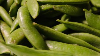Taze, canlı yeşil bezelyelerin yakın görüntüsü, mükemmel renklerini ve eşsiz doğal dokusunu vurguluyor..