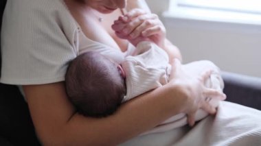 Sevgi dolu bir anne bebeğini rahat ve güvenli bir odada emziriyor..