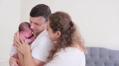 Sevgi dolu ebeveynler yeni doğmuş bebeği huzurlu ve sevecen bir aile evinde beşiyorlar..