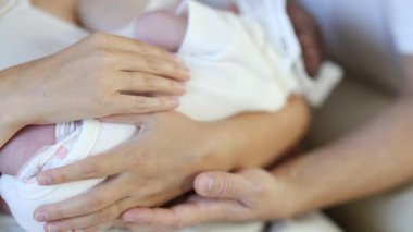 Sevecen ebeveynler değerli yeni doğan bebeklerini kollarında sıcak bir ortamda, yakın planda tutarlar..