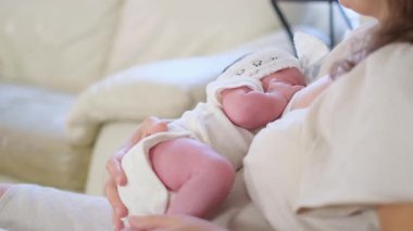 Sevgi dolu anne yeni doğmuş bebeği rahat ve hassas bir evde emziriyor..