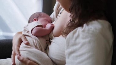 Bir annenin bebeğini nazikçe emzirdiği, derin iç ilişkilerini vurguladığı ve bağ kurduğu huzurlu bir sahne.