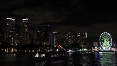 Miami 'nin göz kamaştırıcı bir gece manzarası parlayan bir dönme dolabı ve körfez sularında yansımaları var..