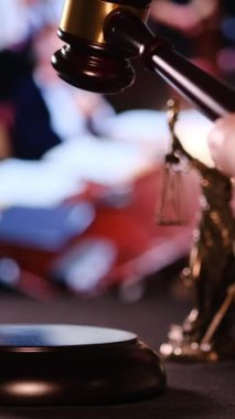 Mahkemede adaleti ve yasal kararları sembolize eden bir tokmağa zorla vurmak. Dikey video. 