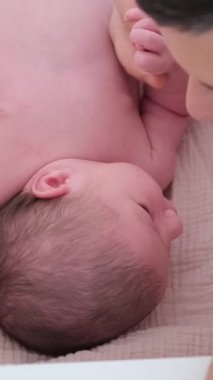 Sevgi dolu baba, sevimli yeni doğmuş bebeğiyle neşeli bir anı paylaşıyor ve güzel bağlarını vurguluyor. Dikey video.