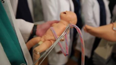 Sağlık uzmanları, el bilgisayarı pratik eğitimi için son derece gerçekçi bir simülasyon bebeği kullanır..