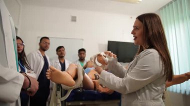 Öğrenciler, öğrenmelerini hızlandırmak için sınıfta gerçekçi bir manikinle el eğitimi alıyorlar..