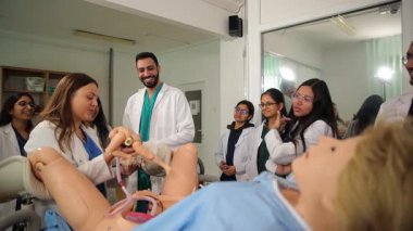 Tıp öğrencileri, klinik öğrenme ortamında hamilelik simülatörü kullanarak aktif olarak pratik eğitime katılıyorlar..
