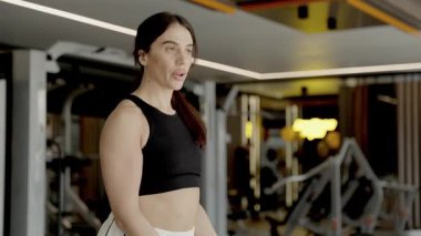 Atletik kadın şık bir spor salonunda çeşitli etkili eğitim teknikleri gösteriyor. Dikey video.