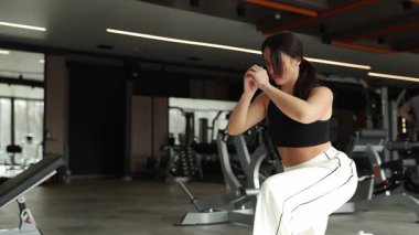 Parlak ve modern bir spor salonunda, yetenekli bir kadın etkili ve enerji verici egzersiz teknikleri sergiler.