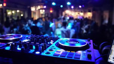 Enerjik DJ 'ler, renkli ışıklar ve bir atmosfer yaratan hareketli bir kalabalık..