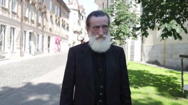 Sakallı yaşlı adam tarihi caddede güven içinde yürüyor..