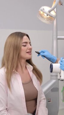 Modern klinik ortamında dişçi muayenesi yaptıran bir hasta. Dikey video.