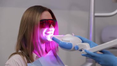 Diş hekiminde ileri düzeyde lazer tedavisi gören hasta diş beyazlatma prosedüründen geçiyor.. 