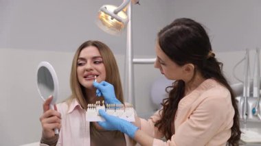 Eğitimli bir diş hekimi, hastanın kozmetik kaplamaları için ideal gölgeyi seçmesine yardımcı olur..