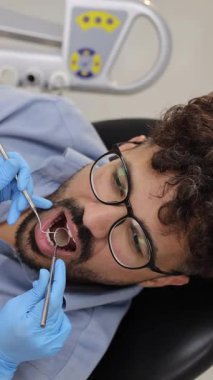 Modern bir klinikte detaylı bir diş muayenesi geçiren bir hastanın yakından görüntüsü, gelişmiş ekipman, hassasiyet ve profesyonel bakım.