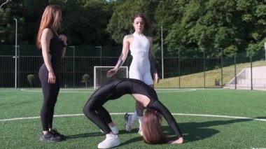 Mankenler çeşitli akrobatik pozlar sergiliyor ve hareketli bir futbol sahasında olağanüstü bir takım çalışması sergiliyorlar.