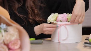 Zarif çiçek aranjmanları yaratmak için yumuşak pastel çiçekleri kullanarak şık beyaz bir kapta düzenlenir.