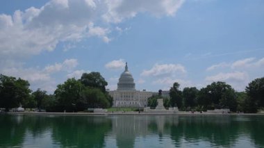Capitol 'ün güzel manzarası mavi gökyüzünün altında sakin bir gölette mükemmel bir şekilde yansıtılır.