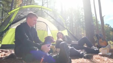 Huzurlu bir orman ortamında aile, evcil hayvanlar, neşeli müzik ve sıcak güneş ışığı ile neşeli bir an..