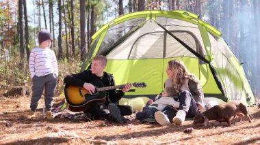 Neşeli bir aile, güzel bir orman ortamında kamp yaparken müzik yapmaktan ve birlikte vakit geçirmekten zevk alır.