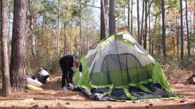Kampçılar sessiz ormanda unutulmaz ve rahatlatıcı bir doğa deneyimi için geniş bir çadır kurarlar..
