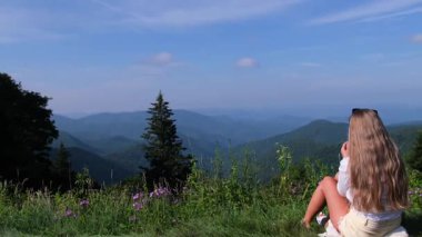 Doğada sakin bir kadın figürü tarafından tamamlanmış nefes kesici manzaralı bir dağ manzarası..