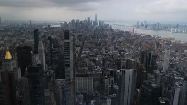 New York şehrinin ikonik mimarisini ve bulutlu gökdelenlerin altındaki çarpıcı gökdelenlerini gösteren nefes kesici bir hava görüntüsü..