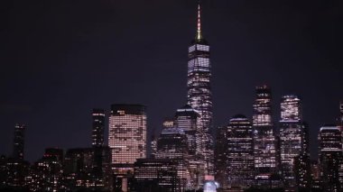 Geceleri büyüleyici bir New York silueti Özgürlük Kulesi gibi ikonik binalar sergiliyor, manzarayı aydınlatıyor.