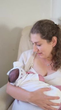 Sıcak, rahat bir ortamda bebeğini emziren şefkatli bir anne sahnesi..