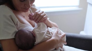 Yumuşak, rahat ve huzurlu bir ortamda bebeğini sevgiyle emziren bir annenin sıcak ve samimi bir sahnesi..