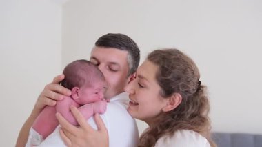 Sevgi dolu bir aile, değerli yeni doğan bebekleriyle sıcak, rahat bir ortamda hassas bir anın tadını çıkarıyor.