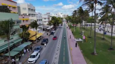Arabalar, palmiye ağaçları ve renkli sanat deco otelleri olan Miamis Ocean Drive 'ın insansız hava görüntüsü. Güneşli tropikal havada popüler turist caddesi