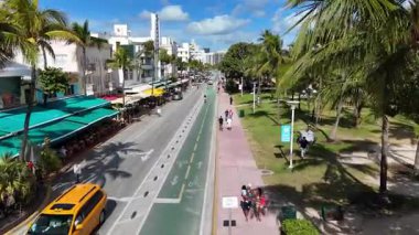 Miami Plajı 'ndaki Ocean Drive' ın insansız hava aracı görüntüleri. Palmiye ağaçları, bisiklet yolları, arabalar ve sanat deco mimarisi. Güneşli havalarda ünlü turist caddesi