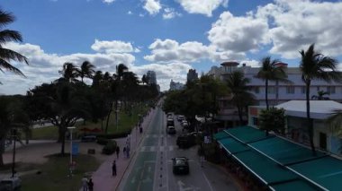 Miami 'deki ünlü Ocean Drive caddesinin hava aracı görüntüsü. Palmiye ağaçları, arabalar ve sanat deco binaları. Tropikal şehir atmosferiyle güneşli bir gün
