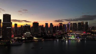 Güneşin doğuşuyla Miami ufuk çizgisinin Drone görüntüsü. Renkli gökyüzü suya yansıyor. Şehir binaları ve sakin deniz kenarı sabahın erken saatlerinde