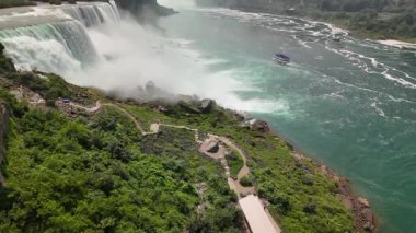 Niagara Şelalesi 'nin insansız hava aracı görüntüsü nehir kıyısında bir gözlem güvertesi bulunan güçlü bir su ve sisi gösteriyor..