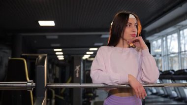 Spor salonunda durup kameraya bakan güzel bir esmerin portresi. Güzel fitness kadını. Güzellik ve sağlıklı vücut kavramı