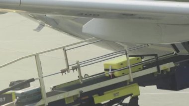 Yer ekibinin havaalanı terminalindeki kargo ambarına bagajlarını yüklediği yakın çekim görüntüsü. Ulaştırma ve seyahat sektörü kavramı.