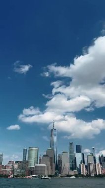 Bir Dünya Ticaret Merkezi ve ABD 'nin New York şehrinde hareket eden bulutların altındaki modern gökdelenleri çevreleyen Manhattan siluetinin dikey zaman çizelgesi videosu.