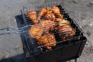 Kızarmış tavuk ızgara barbekü kanatları ve bacaklar yaz pikniğinin dışında leziz et yemeğiyle kızartılmış mangal. İnsan yok, yatay çekim, yakın plan, gri arkaplan