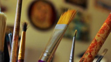 Yaratıcılığın Fırçaları: Sanatsal bir boya fırçası. Bu büyüleyici görüntü, canlı renklere batırılmış bir dizi resim fırçasını içeriyor, her bir fırça, sanatçının paleti ve vizyonunun bir kanıtıdır.. 