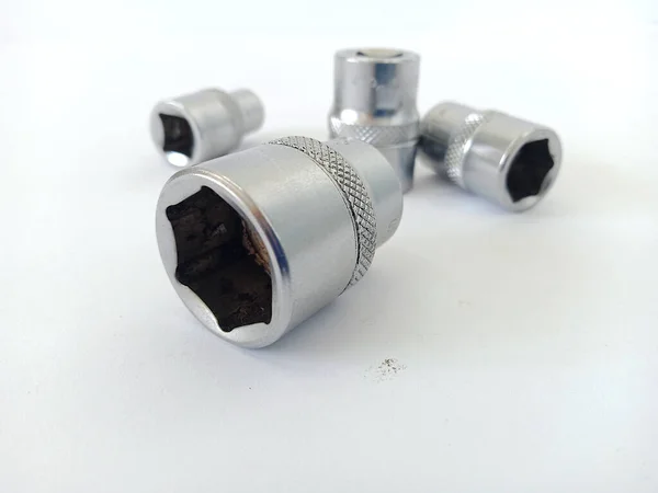 Gümüş renkli kaliteli demirden yapılmış birkaç soket anahtarının yakın plan fotoğrafı, bu anahtarlar cıvataları açmak ve sıkmak için kullanılıyor