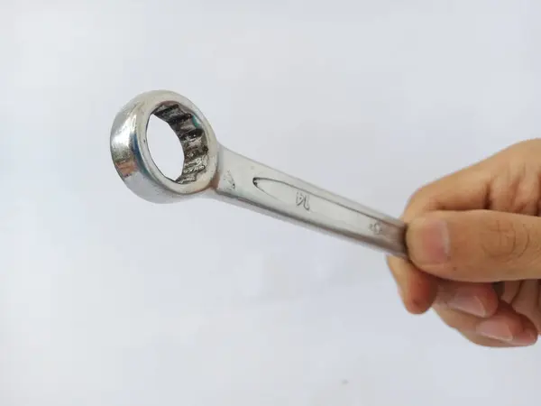 14 numara bir İngiliz anahtarlığının yakın plan görüntüsü. Krom kaplamalı 14 ingiliz anahtarı yüzüğü insan eliyle beyaz arka planda beyaz bir arka planda insan eliyle tutulmuş.