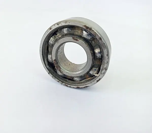 Kullanım nedeniyle hasar görmüş, kirli ve paslı görünen bir yatağın görüntüsü, beyaz arka planlı bir stüdyoda çekilmiş.