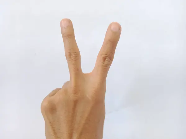 A photo of a hand making a peace symbol on a white background in the studio